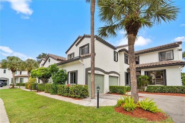 mediterranean / spanish house with a garage and a front lawn