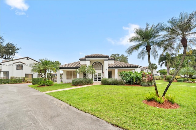 mediterranean / spanish house featuring a front yard and french doors