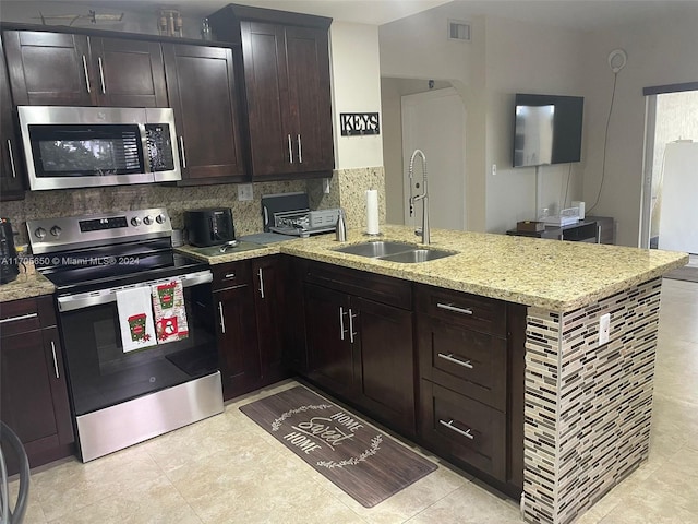 kitchen featuring dark brown cabinetry, sink, and appliances with stainless steel finishes