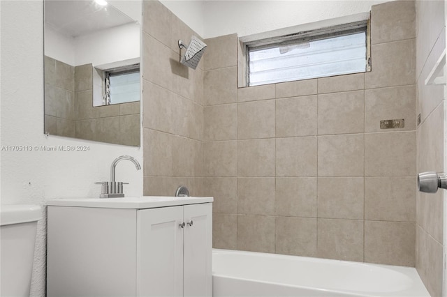 full bathroom featuring toilet, vanity, and tiled shower / bath