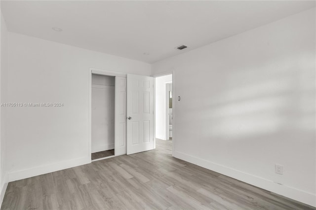 unfurnished bedroom featuring light wood-type flooring and a closet