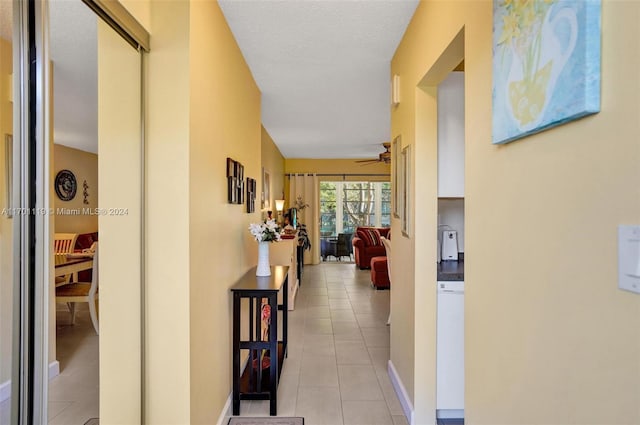 hallway featuring light tile patterned flooring and a textured ceiling