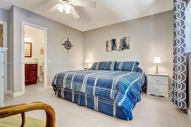 tiled bedroom featuring ensuite bath and ceiling fan