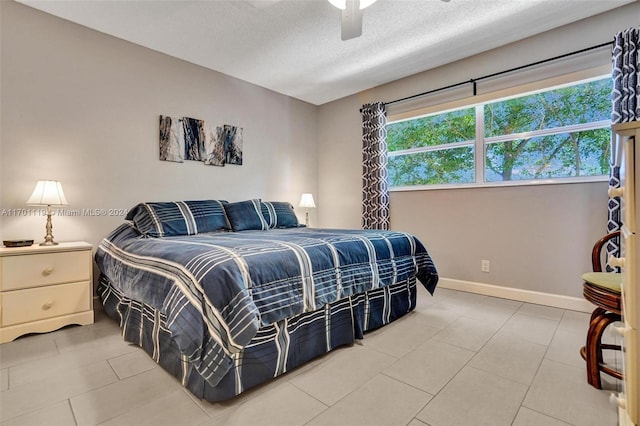 tiled bedroom featuring ceiling fan and a textured ceiling