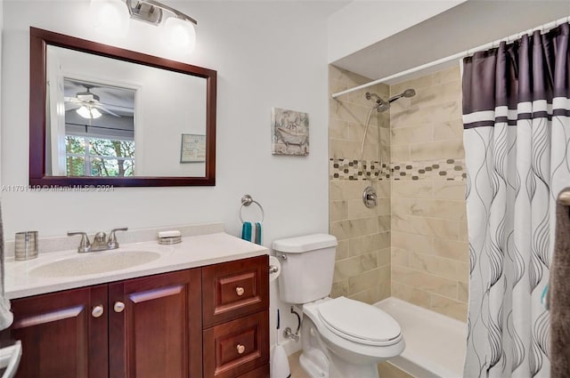 bathroom with walk in shower, vanity, toilet, and ceiling fan