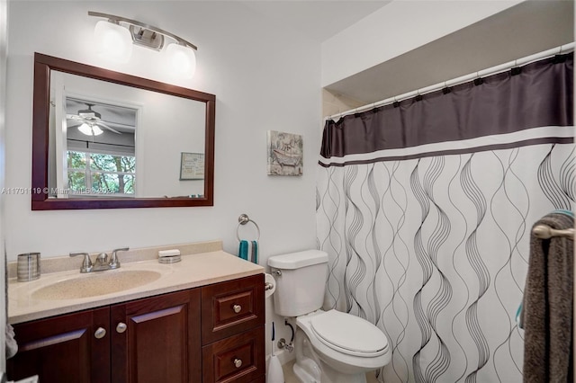 bathroom with a shower with shower curtain, vanity, toilet, and ceiling fan