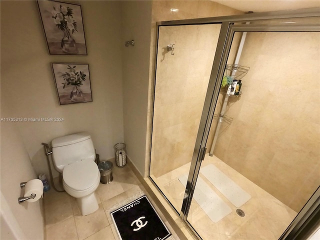 bathroom with tile patterned flooring, an enclosed shower, and toilet