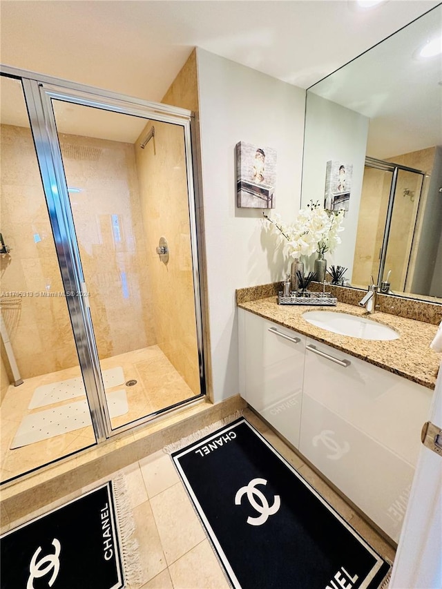 bathroom featuring tile patterned flooring, vanity, and a shower with door