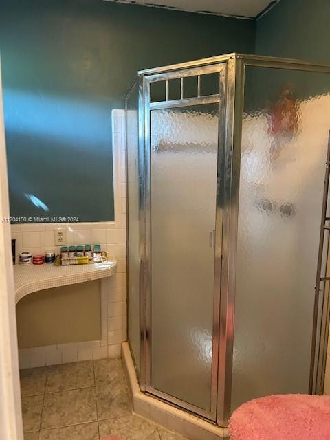 bathroom with tile patterned floors and a shower with shower door