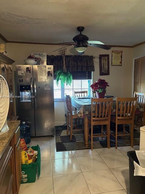 dining room with a textured ceiling, ceiling fan, light tile patterned floors, and ornamental molding