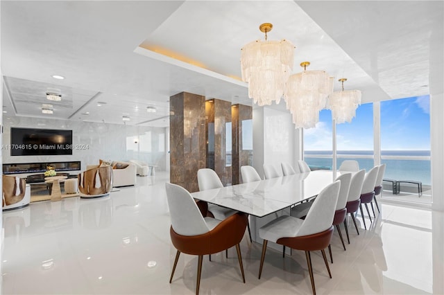 tiled dining area featuring floor to ceiling windows, a water view, and a notable chandelier