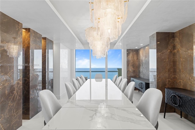 dining room with a water view and an inviting chandelier