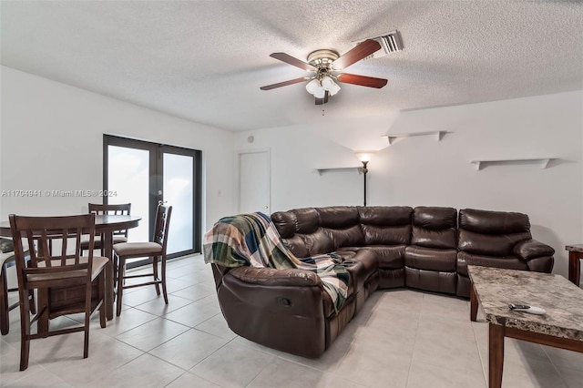 tiled living room with french doors, a textured ceiling, and ceiling fan