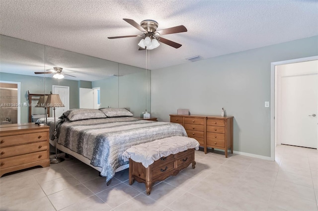 tiled bedroom with ceiling fan and a textured ceiling