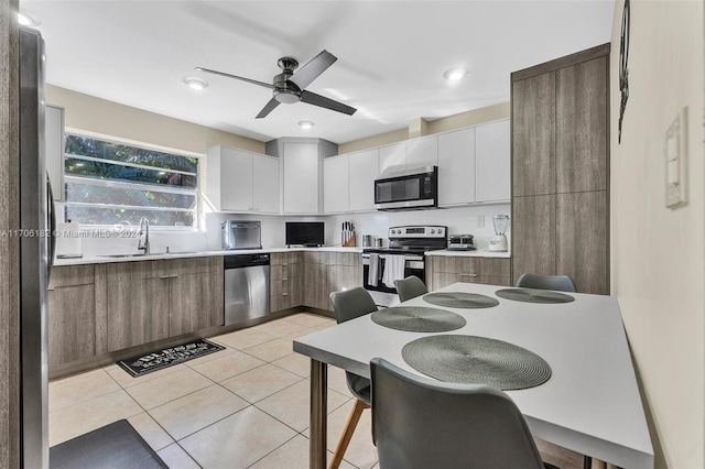 50 SW 130th Ave, Miami, FL 33184 - kitchen featuring ceiling fan, sink, stainless steel appliances, light tile patterned floors, and white cabinets