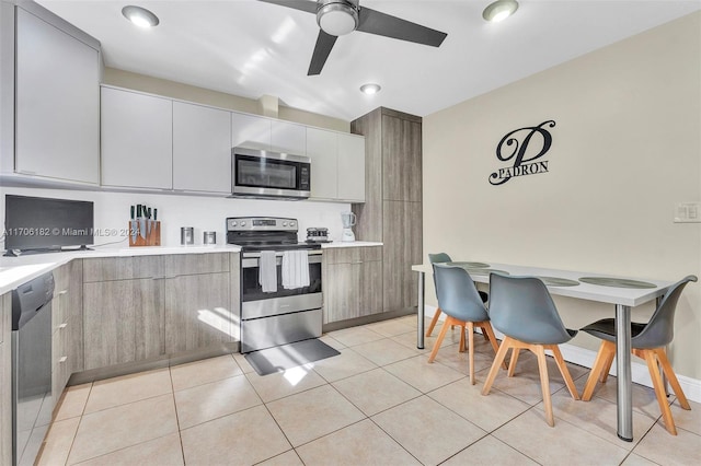 50 SW 130th Ave, Miami, FL 33184 - kitchen featuring gray cabinetry, white cabinets, ceiling fan, light tile patterned floors, and appliances with stainless steel finishes