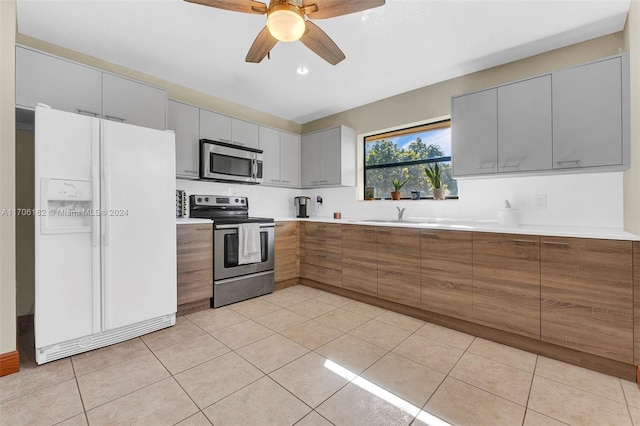 50 SW 130th Ave, Miami, FL 33184 - kitchen featuring appliances with stainless steel finishes, ceiling fan, sink, light tile patterned floors, and gray cabinets