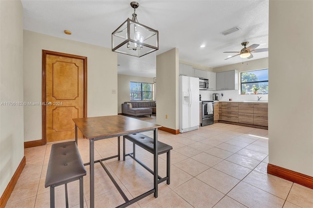 50 SW 130th Ave, Miami, FL 33184 - tiled dining space featuring a wealth of natural light and ceiling fan with notable chandelier