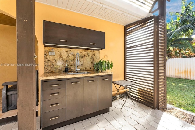 50 SW 130th Ave, Miami, FL 33184 - exterior space with backsplash, dark brown cabinetry, light stone counters, and sink