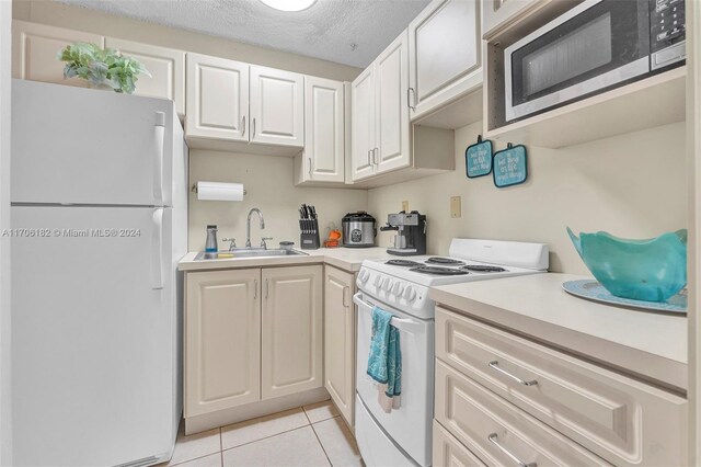 50 SW 130th Ave, Miami, FL 33184 - kitchen with a textured ceiling, white appliances, sink, light tile patterned floors, and white cabinetry