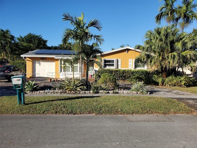 view of front facade with a garage and solar panels