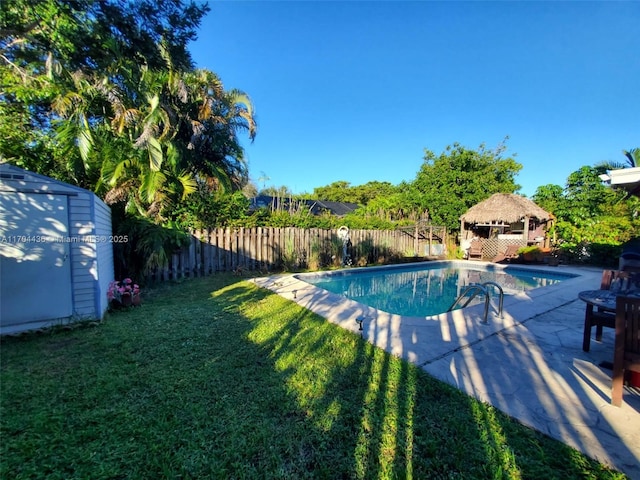 view of swimming pool with a patio area, a gazebo, a yard, and a storage shed