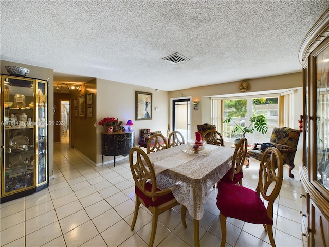 dining area featuring light tile patterned flooring and a textured ceiling