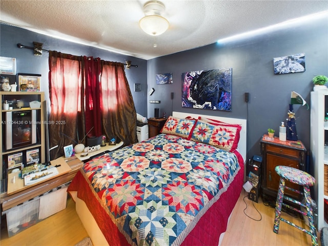 bedroom with a textured ceiling and light wood-type flooring