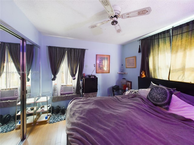 bedroom featuring ceiling fan, cooling unit, a textured ceiling, and light hardwood / wood-style flooring