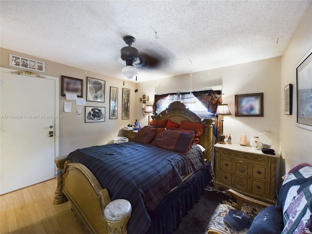 bedroom with ceiling fan, a textured ceiling, and hardwood / wood-style floors