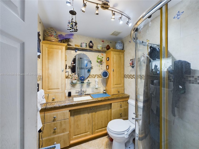 bathroom featuring tile patterned floors, toilet, walk in shower, and vanity