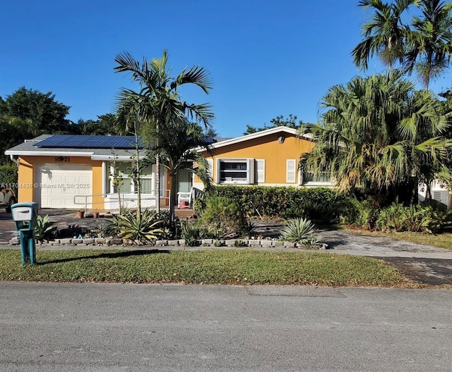 view of front of home featuring solar panels and a garage