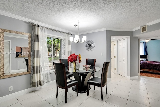 tiled dining room featuring a chandelier, a textured ceiling, and ornamental molding