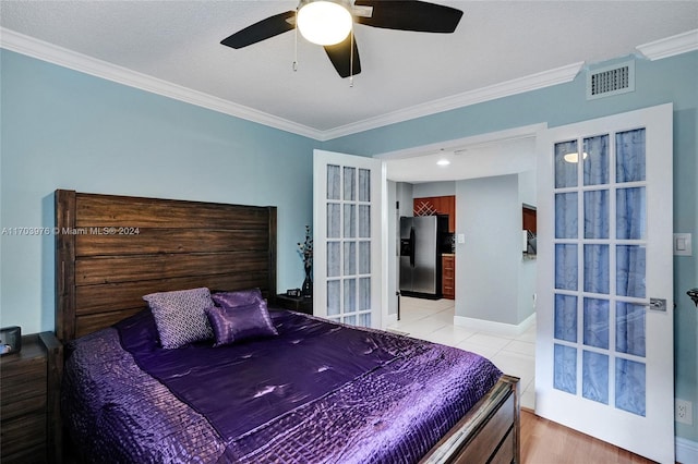 bedroom with ceiling fan, stainless steel fridge, light tile patterned floors, a textured ceiling, and ornamental molding