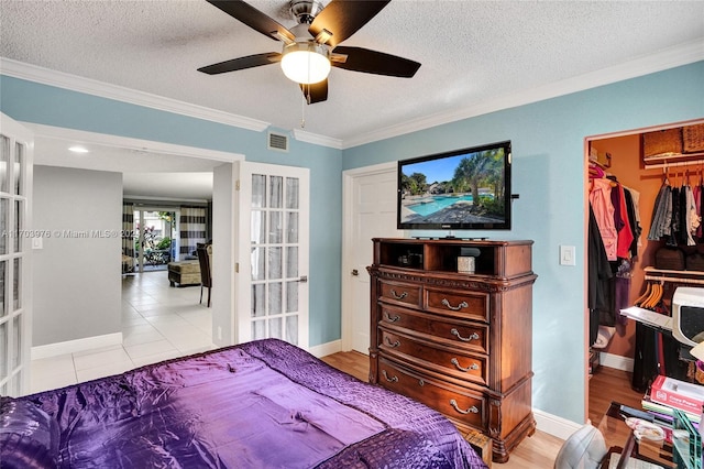 bedroom with a textured ceiling, a closet, ceiling fan, and crown molding