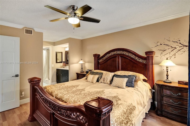 bedroom featuring ensuite bath, ceiling fan, ornamental molding, a textured ceiling, and wood-type flooring