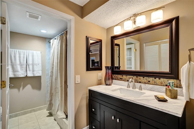 bathroom with walk in shower, tile patterned flooring, a textured ceiling, decorative backsplash, and vanity