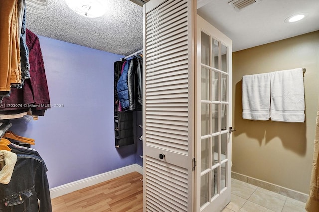 spacious closet featuring french doors and light wood-type flooring