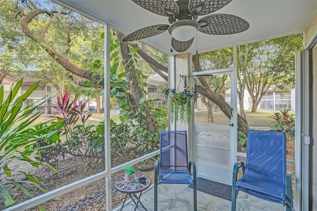 unfurnished sunroom with ceiling fan