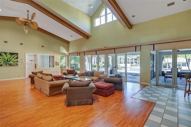 living room with beam ceiling, ceiling fan, french doors, light hardwood / wood-style flooring, and high vaulted ceiling