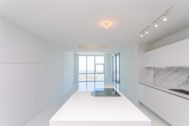 kitchen featuring a center island, black electric cooktop, and white cabinetry