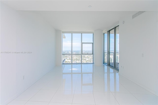 tiled spare room with floor to ceiling windows