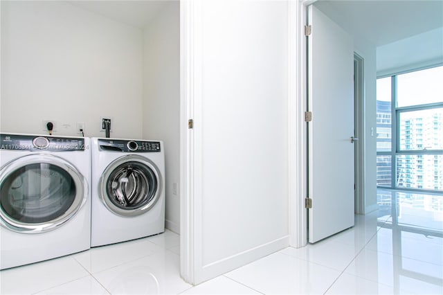 laundry room featuring light tile patterned floors and washer and clothes dryer