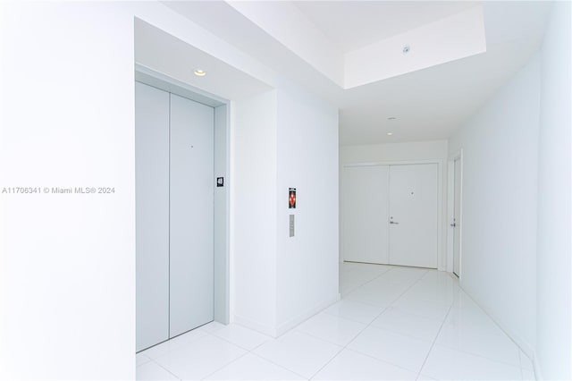 hall with light tile patterned floors and elevator