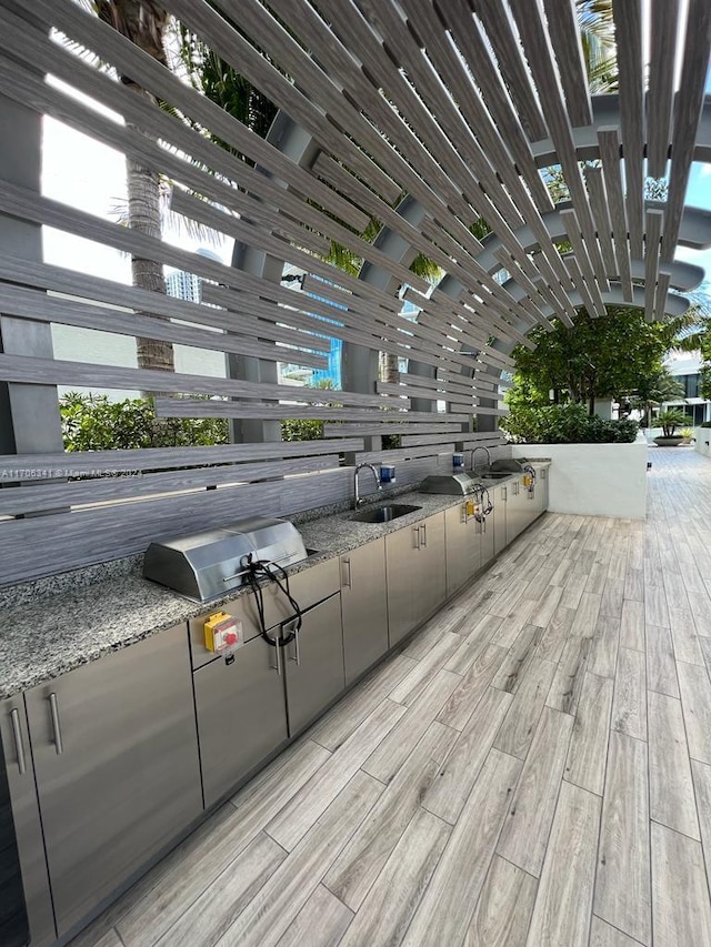 exterior space with a grill, sink, and an outdoor kitchen