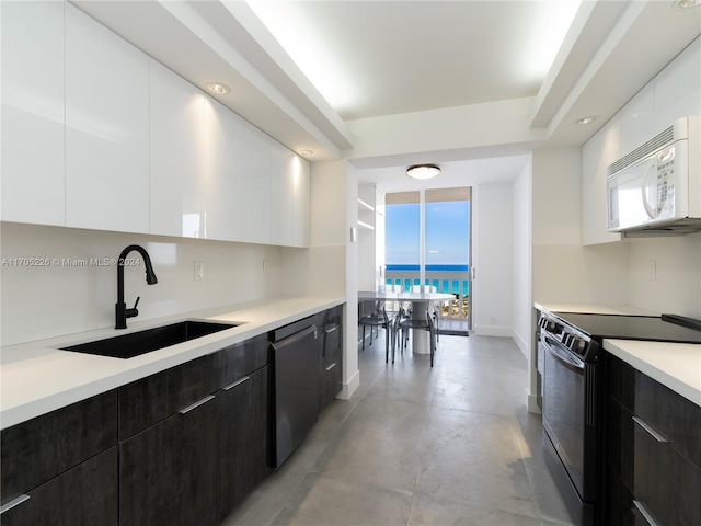 kitchen featuring white cabinetry, a wealth of natural light, sink, and black range with electric cooktop