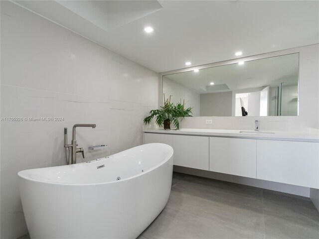 bathroom featuring a tub to relax in, vanity, and concrete flooring