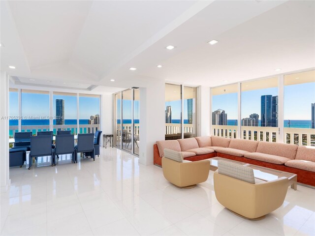 tiled living room featuring expansive windows and a water view