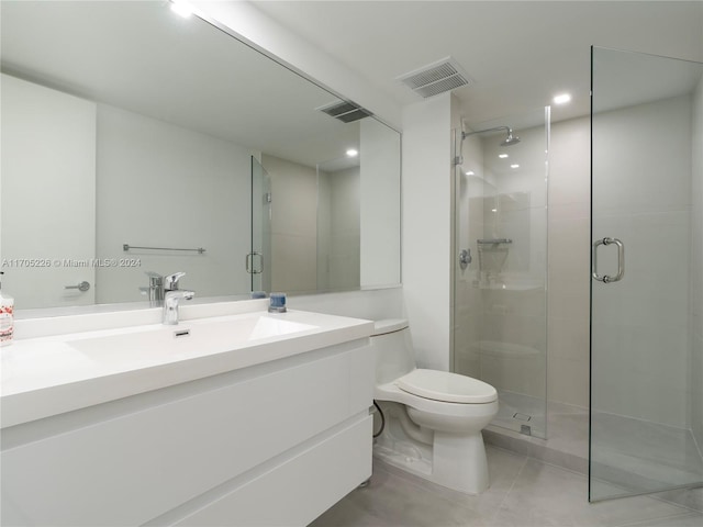 bathroom with tile patterned flooring, vanity, toilet, and walk in shower