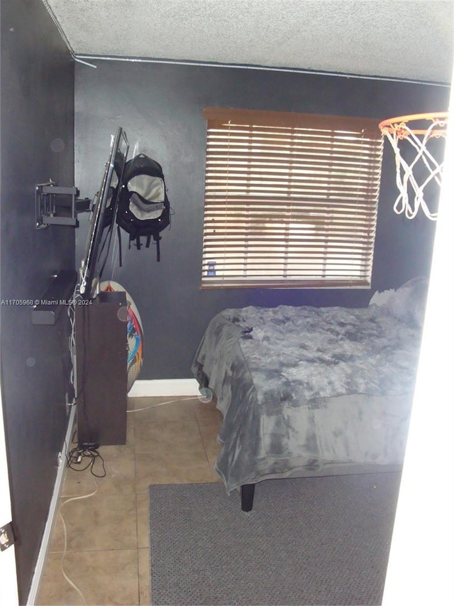 bedroom with tile patterned floors and a textured ceiling